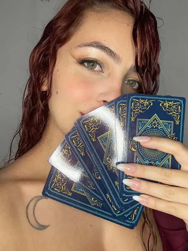 Kamilly com olhar místico e cartas de tarot
